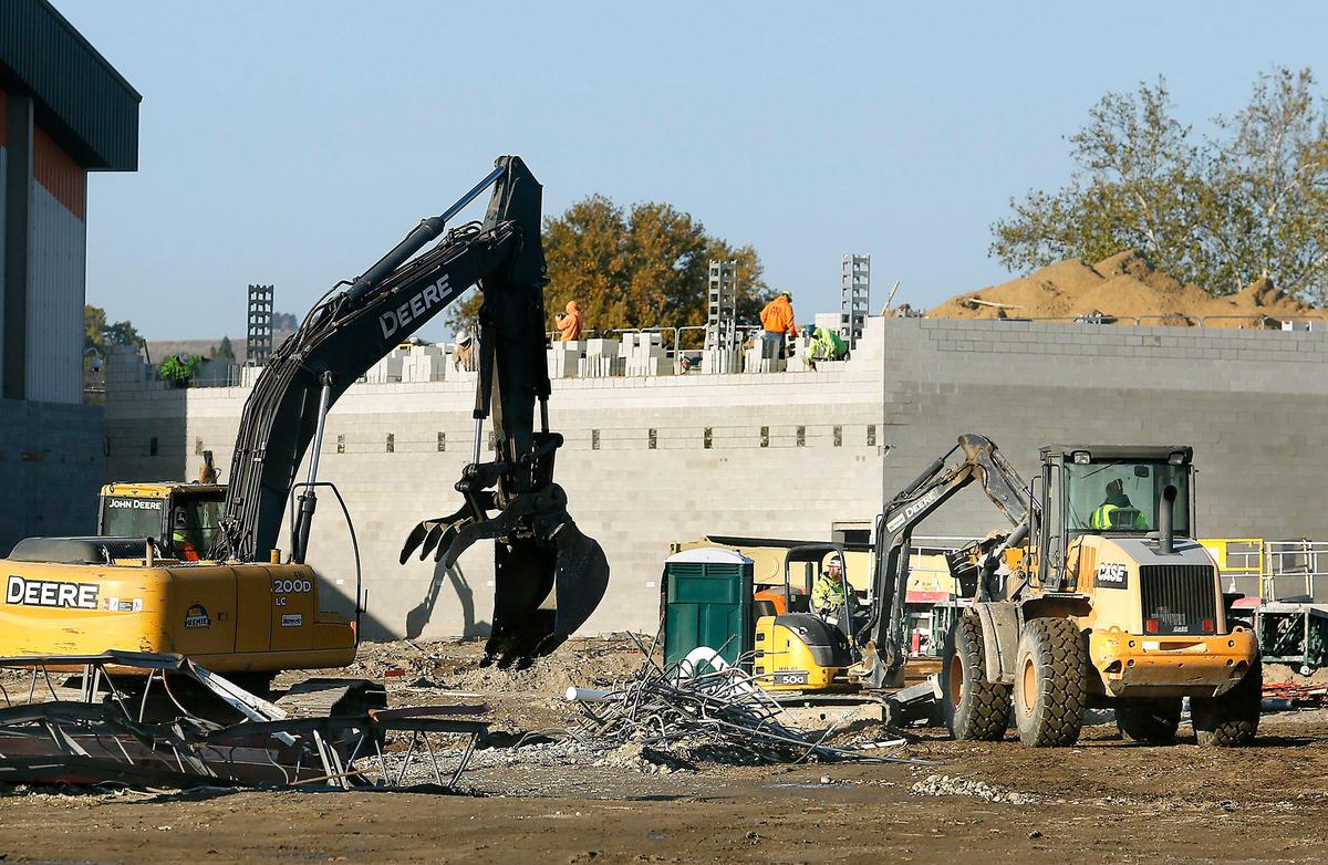 Heavy equipment moves debris and dirt while masonry workers build a section of the new Kennewick High School building. Watch videos at: tricityherald.com/videos