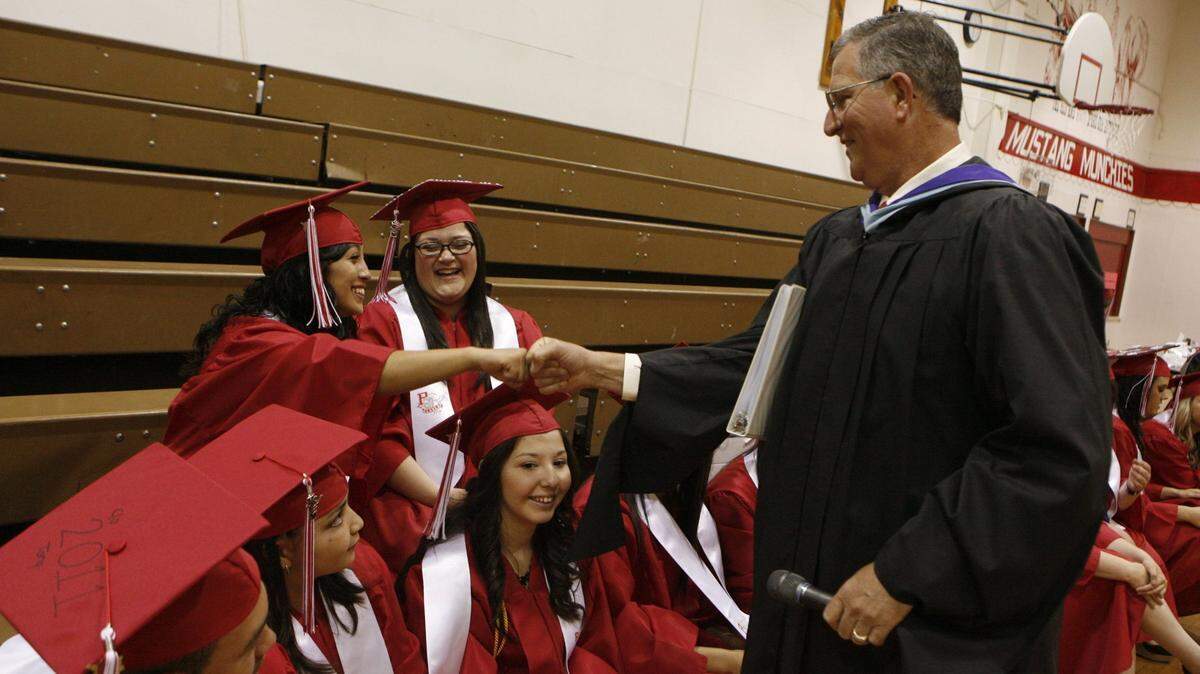In 2011, then-Principal Kevin Lusk bumps fists with students during Prosser High School’s graduation ceremony.