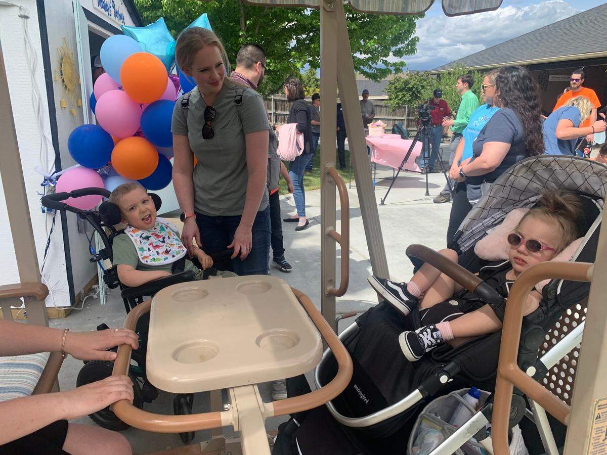 Millie George tries the new swing for immobilized kids at the Wishing Star wish reveal, joined by Kade Korstvedt.