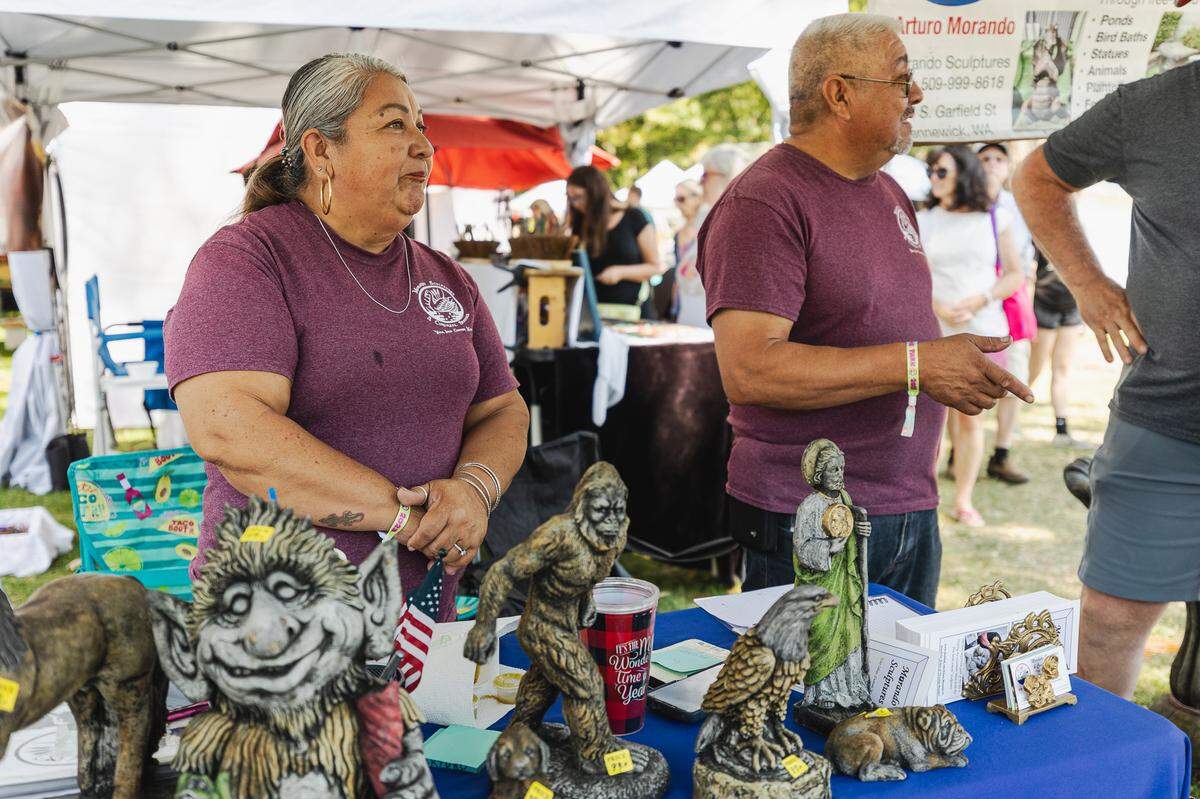 Anturo Morando and his wife sell their scultpures from cement and concrete statues at the Art in the Park Festival.