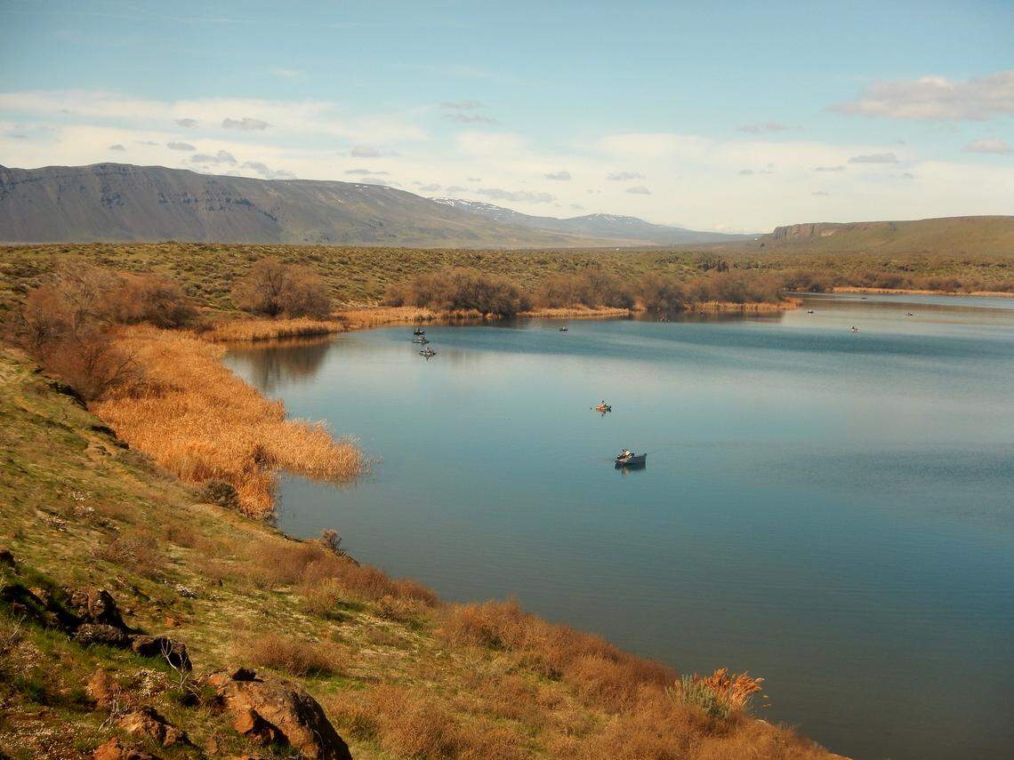 Fly casters on personal floating devices scatter across Lenice Lake on a spring day before a range fire scarred the desert landscape.