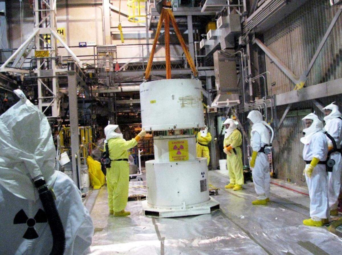 Hanford workers wearing protective gear take apart a cask at Hanford’s K West Basin as work started to deal with radioactive sludge from irradiated fuel stored in the reactor’s cooling pool.