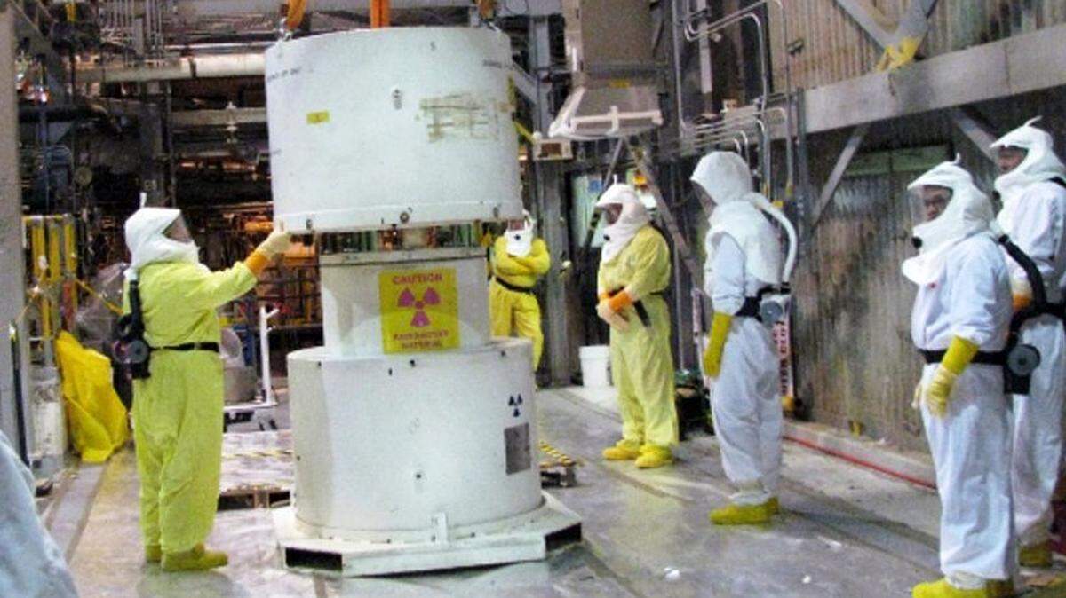 Hanford workers wearing protective gear take apart a cask at Hanford’s K West Basin in this 2024 file photo.