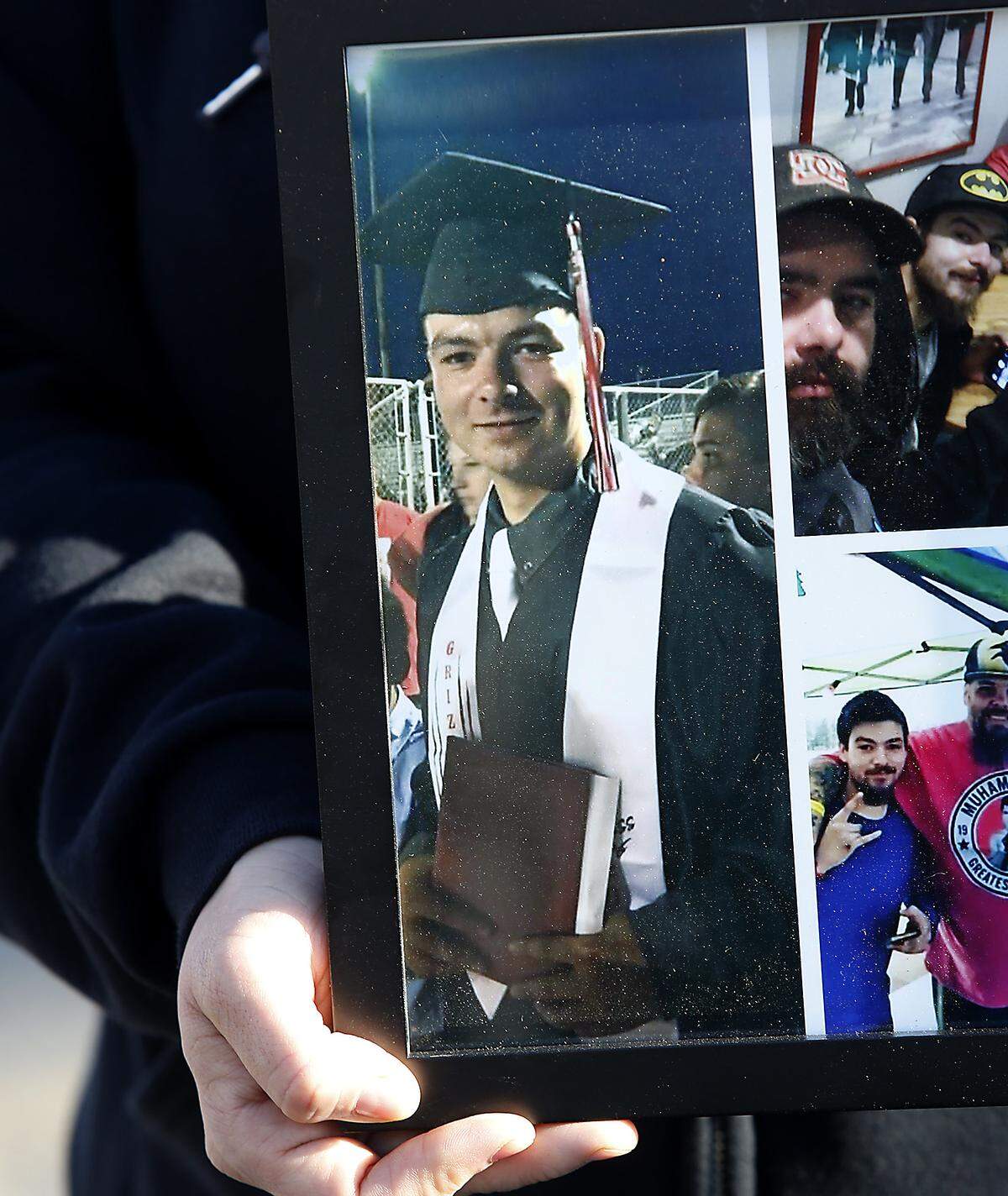 Patricia Martinez, aunt of fatal shooting victim Patrick Steven Romero, holds framed family photos of him, including his graduation from Sunnyside High School, at the makeshift memorial where he was gunned down on West Bruneau Street in Kennewick. Watch a video at: tricityherald.com/videos