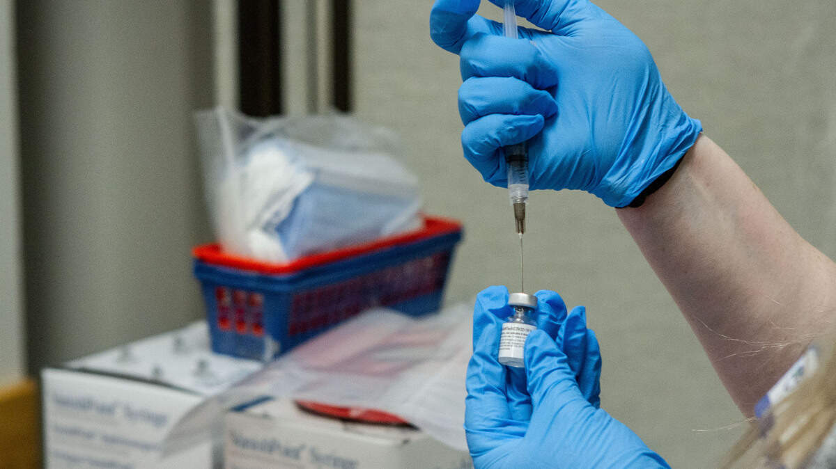 A medical staffer prepares vaccine doses to administer at a vaccine clinic at WSU Tri-Cities in Richland.