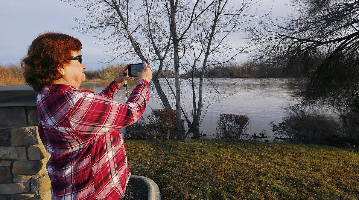 Freda Vermeer of Richland stops on her way to work for a photo of the swollen Yakima River near the bridge into West Richland. Vermeer was a victim of the 1996 flood and was forced to move from her home off Demoss Road because it was inundated with water during the historic event. 
