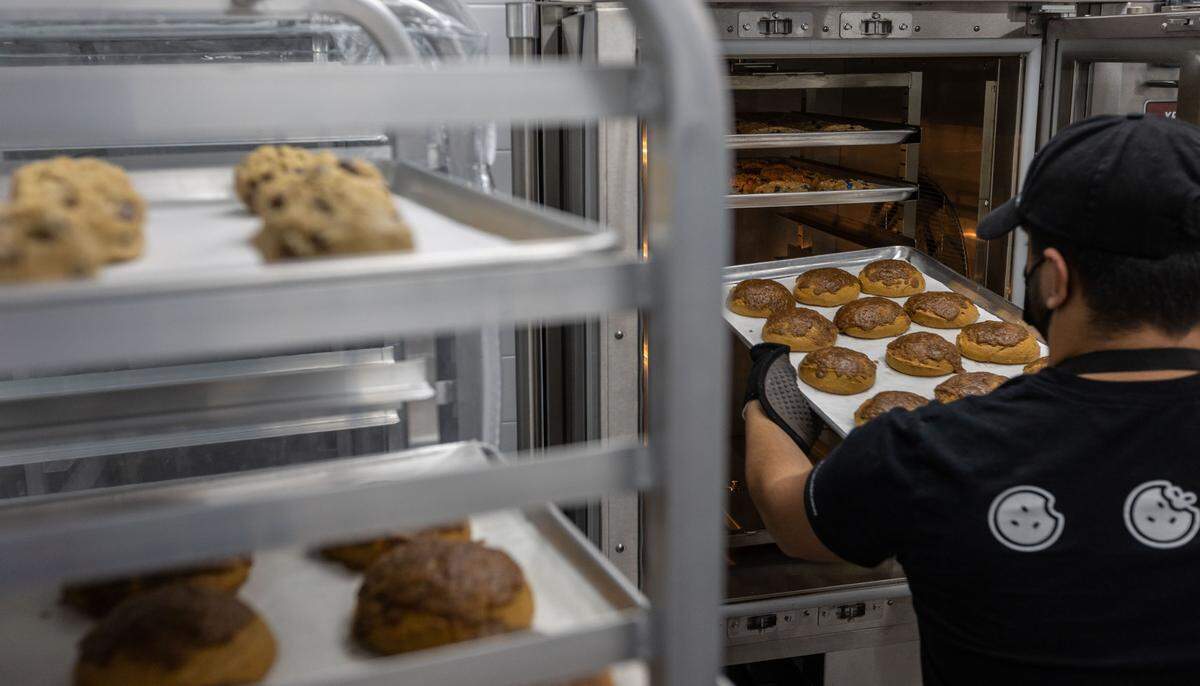Cookies are removed form the oven and placed on cooling racks at Crumbl Cookies in Kennewick. The popular chain made its Tri-Cities debut in Richland in March and will soon have locations in all three cities, with a third set to open in Pasco off of Road 68.