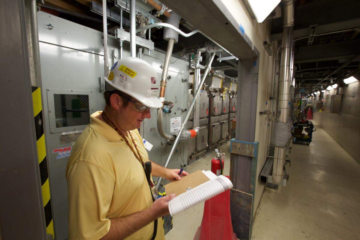 A worker reviews documents near air-handling equipment in the Low Activity Waste Facility at the Hanford vitrification plant. A study is looking at the affects of ash suspended in the air in case of a volcanic eruption.