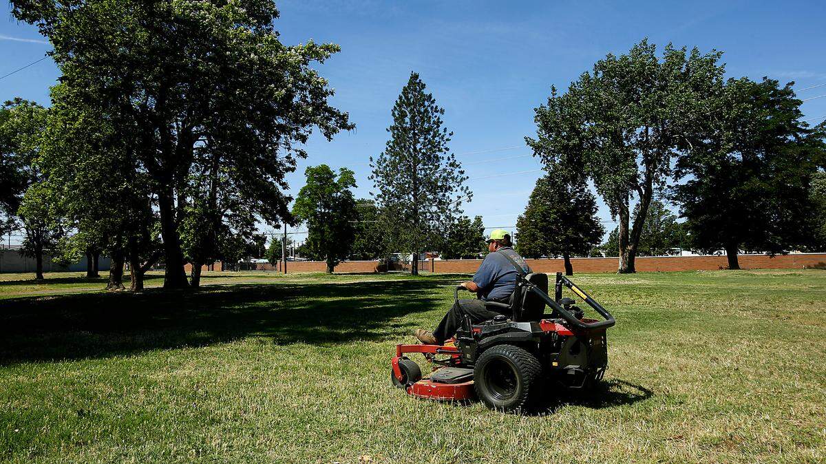 A Port of Kennewick employee mows the grass at the 6.5-acre site of the former Willows Trailer Court near Clover Island in downtown Kennewick that the Port of Kennewick wants to develop for housing.