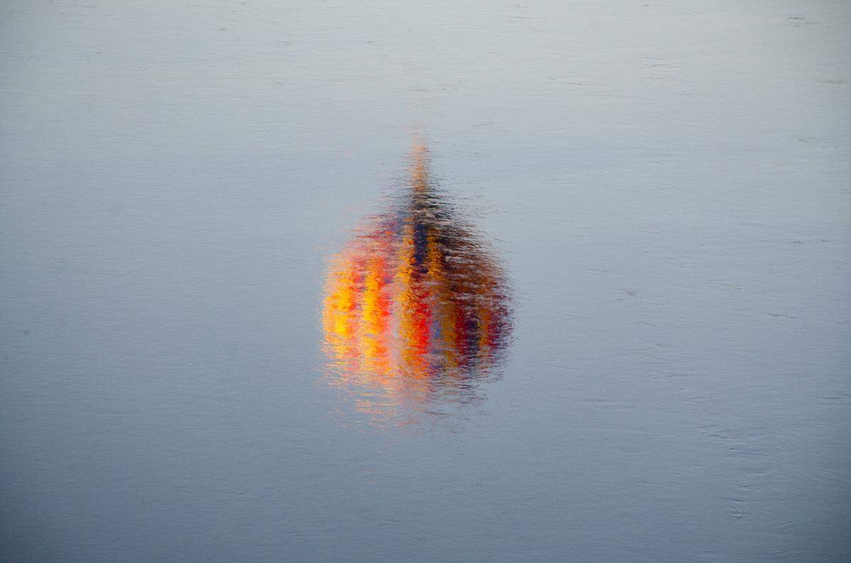 The reflection of a hot air balloon is muddled by the flow of the Yakima River in Prosser, WA early Friday morning.