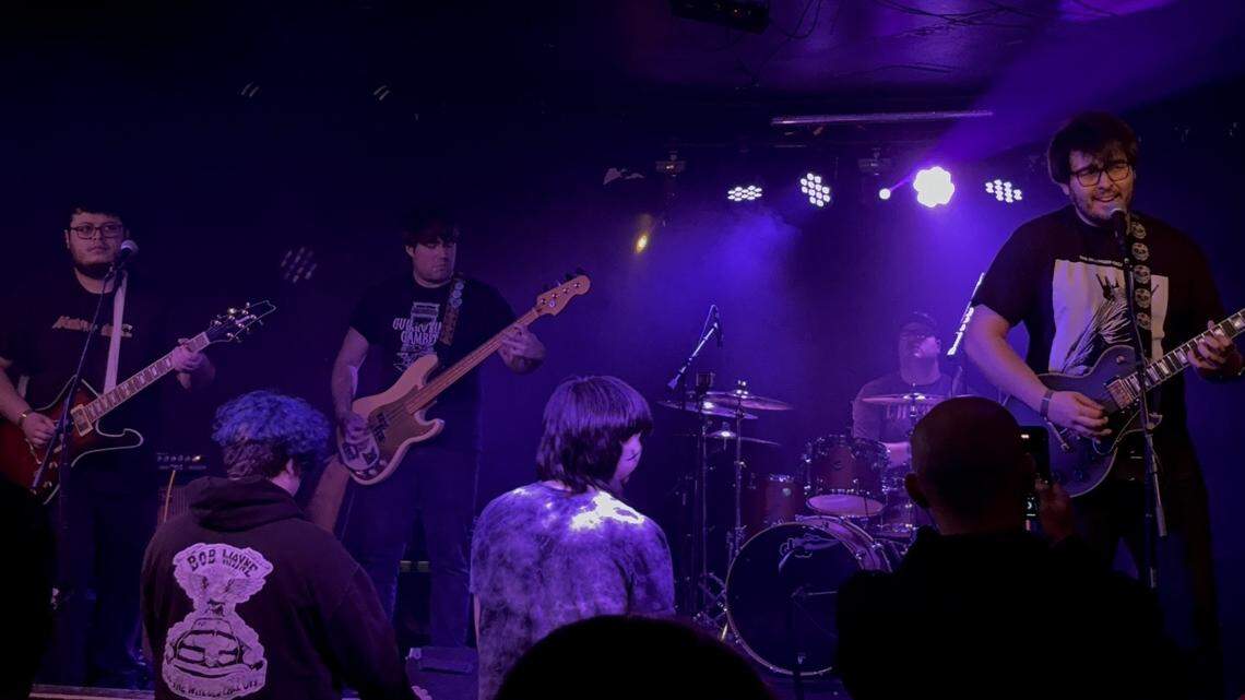 Caleb Warwick, far right, on guitar and vocals for Staring at the Sun onstage at Ray’s Golden Lion on December 28, 2024.