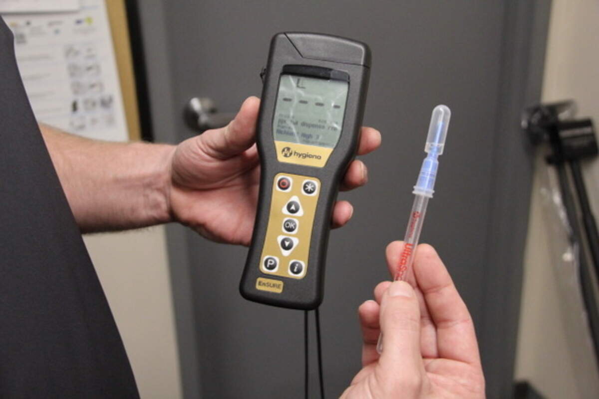 Mark Humann, Richland School District custodial manager, holds an ATP meter and test swab used by school custodians to test recently cleaned surfaces. The device tests for a compound found in living cells.