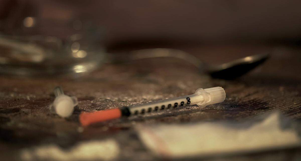 Used syringes and drug powder on dirty table