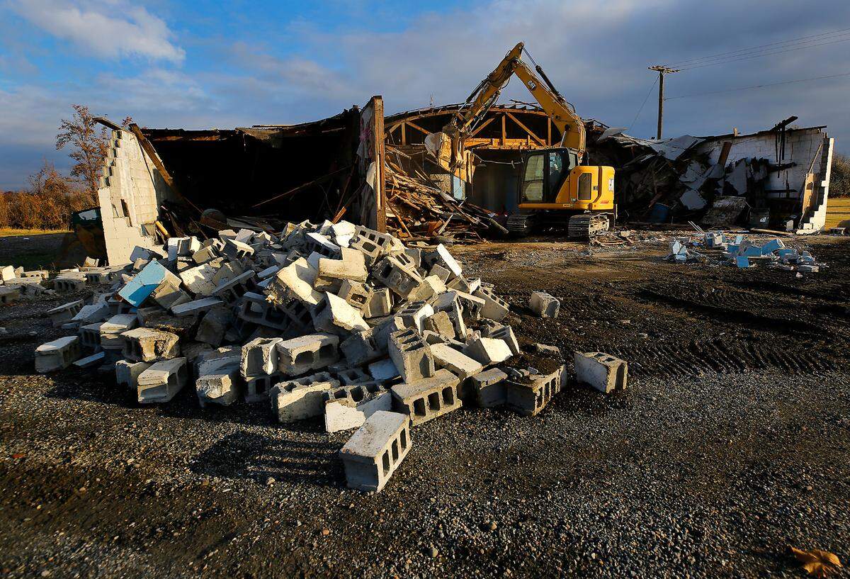 An excavator razes the old parks headquarters building near Edison Street in Columbia Park in Kennewick.