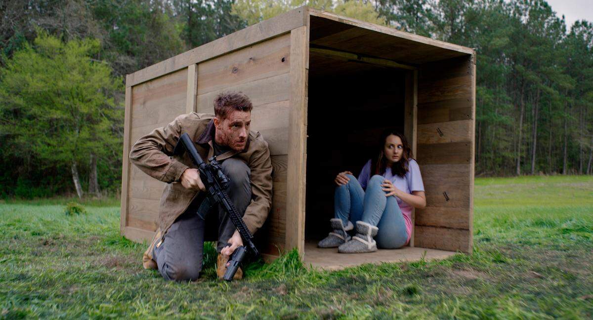 This image released by Universal Pictures shows Justin Hartley, left, and Sylvia Grace Crim in a scene from “The Hunt.” (Universal Pictures via AP)