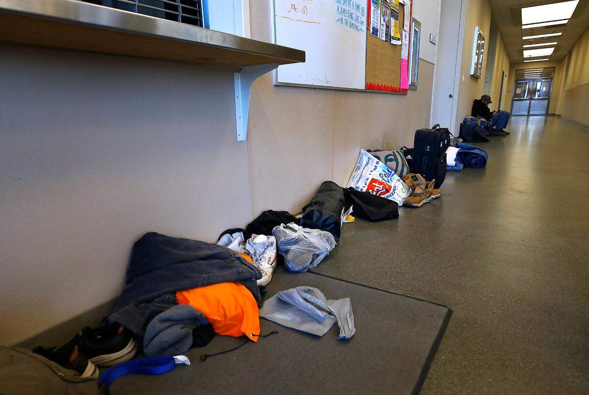Belongings of homeless men seeking relief from the frigid February temperatures line the hallway near the day room at the Tri-City Union Gospel Mission in the facility located at 221 S. 4th Ave. in Pasco.