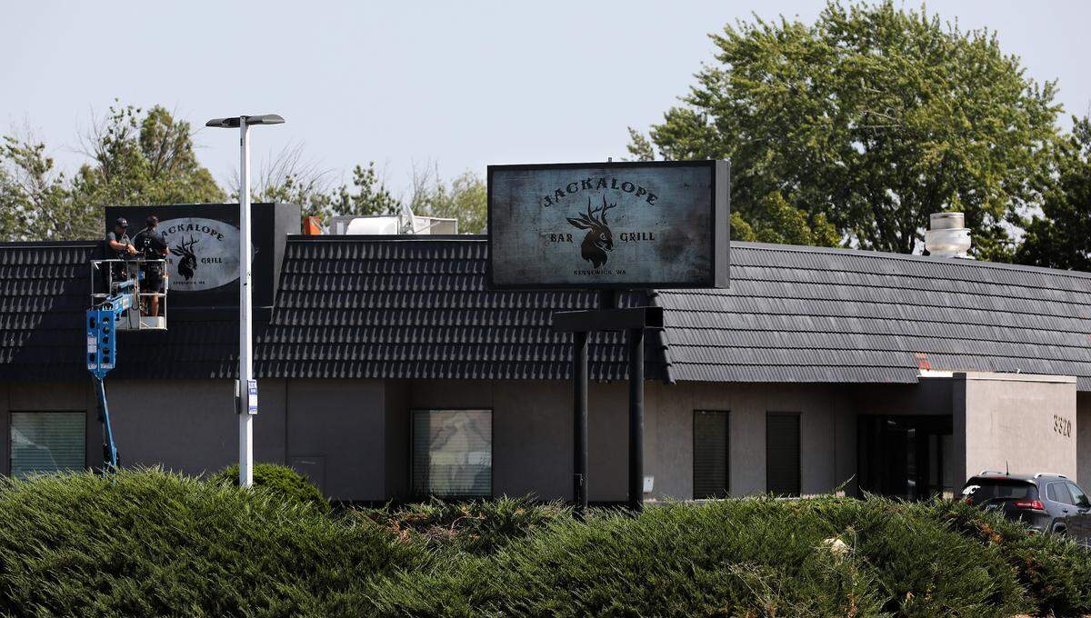 Workers in a lift attach a sign for the Jackalope Bar & Grill location at 3320 W. Kennewick Ave, the former location of Bougie Brunch.