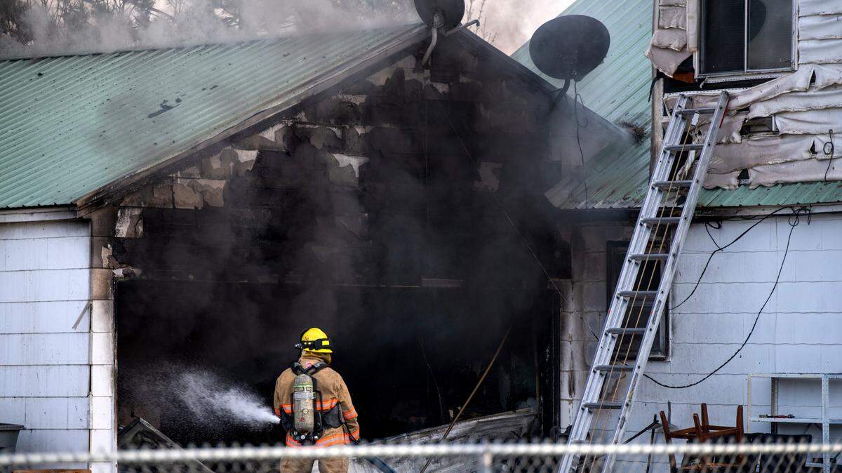 Light smoke rises from a garage as a firefighter sprays water on Thursday’s fire at 1336 Florida Ave. in Richland.