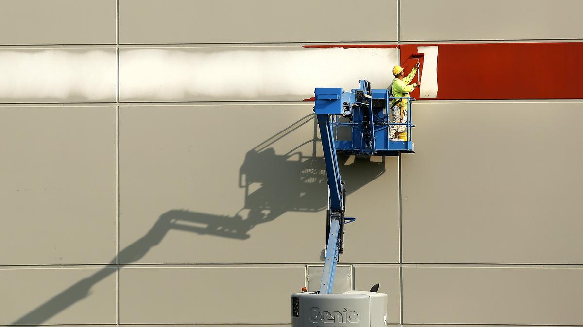 A painter works from a boom lift Thursday putting an accent stripe around a new commercial building at 314 N. Wilson Pl. in Kennewick. The $4-million warehouse features a showroom and office space for Gensco, a regional wholesale distributor of HVAC equipment and supplies. The general contractor is O’Brien Construction of Kennewick.