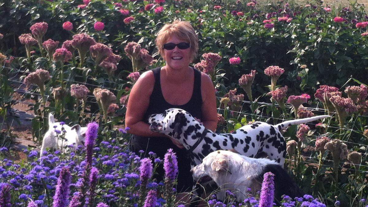 Teresa Engbretson is joined by her family pets in her garden that overlooks the Columbia River near Paterson, Wash.