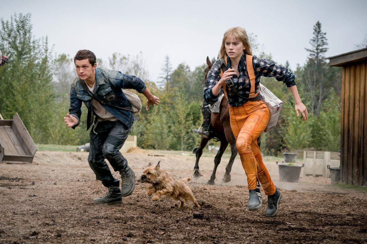 Tom Holland as ‘Todd Hewitt,’ Manchee the dog, and Daisy Ridley as ‘Viola Eade’ in “Chaos Walking.”