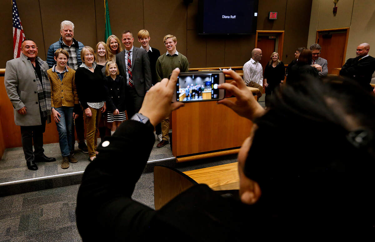 Family and friends pose for a group photo following the swearing in ceremony for Eric Eisinger as the new Benton County prosecutor.