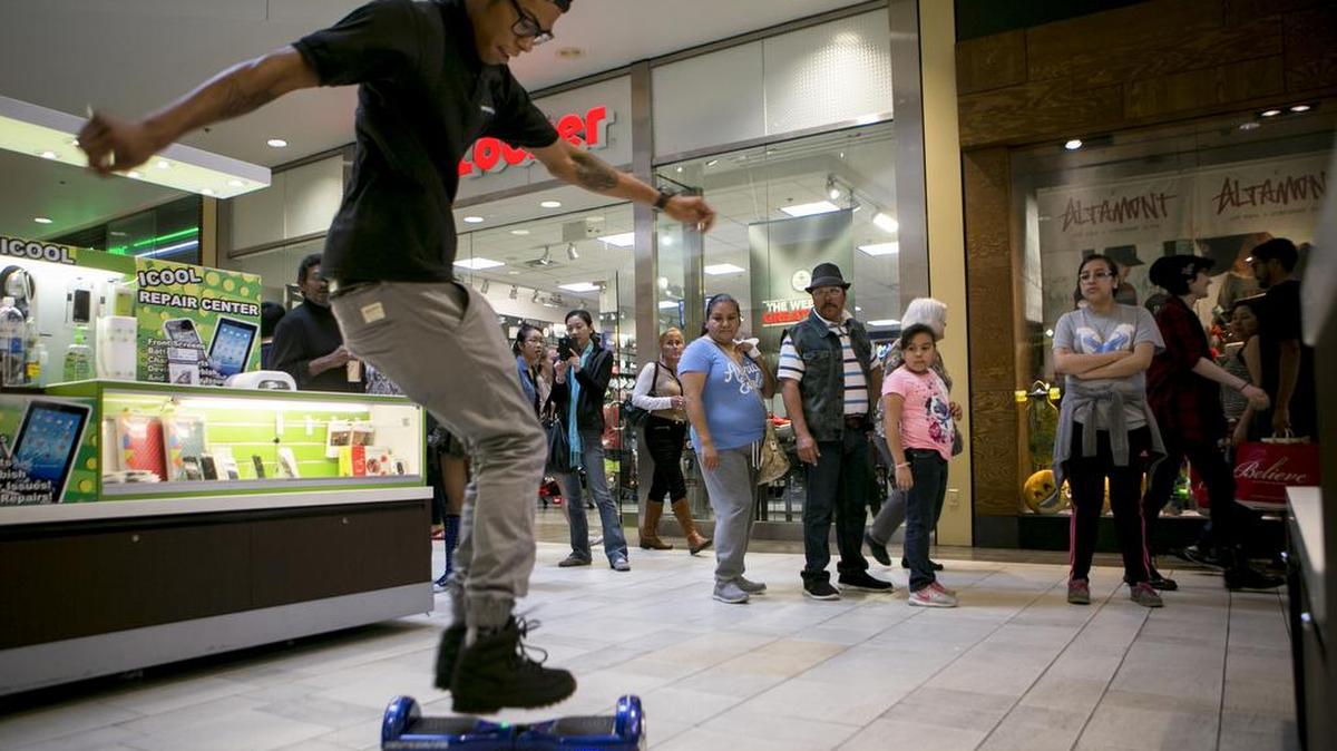 Shannon Clay Jr., performing tricks on a Power Board, a type of hoverboard he sells at a mall kiosk, during Black Friday in Austin, Texas.