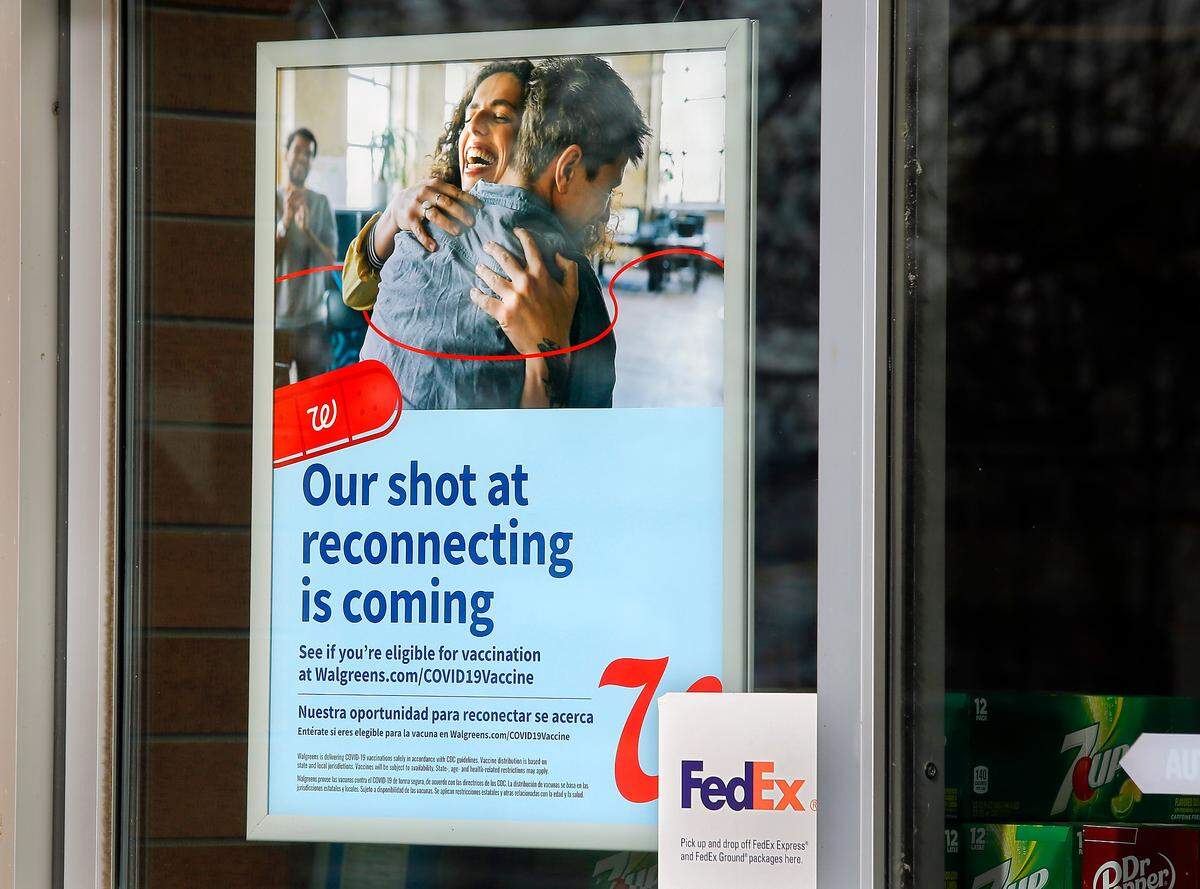 A sign near the front door of a Walgreens pharmacy announces pending availability of the COVID-19 vaccines at the store in Pasco.