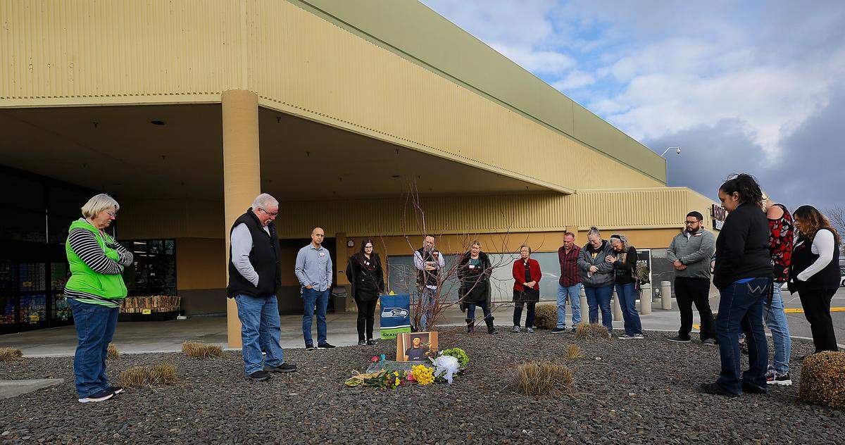 Family and friends gather for a moment of silence to honor Justin Krumbah, on the second anniversary of his shooting death at the Richland Fred Meyer store.