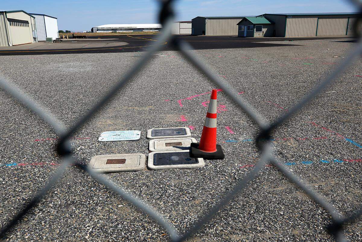 Locating paint surrounds a cluster of water meter covers inside the security fencing near the private hangars at the Port of Benton’s Richland Airport.