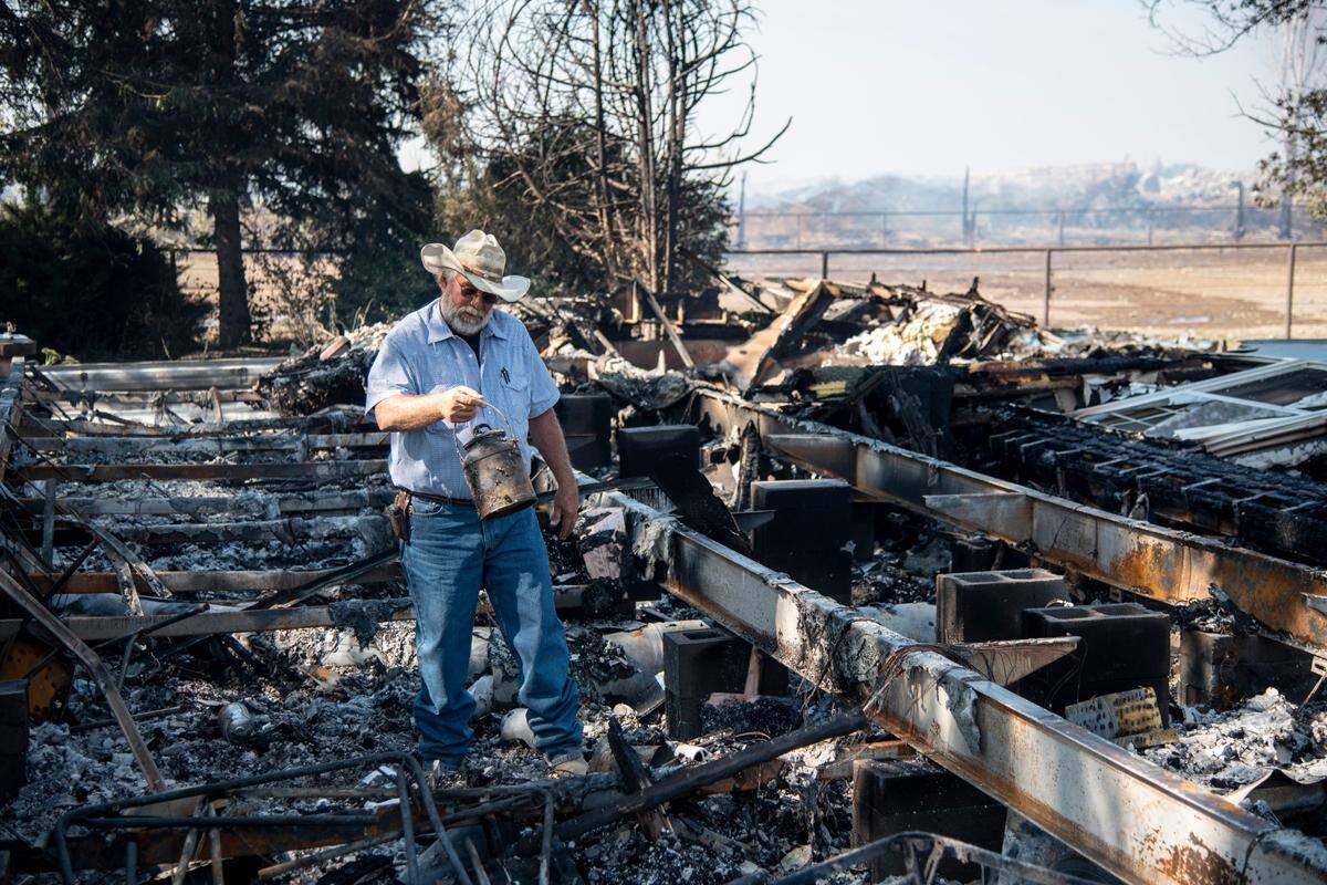 Jim Boogerd picks up a milk pail that was in his family for generations and survived a fire that burned down his house on Labor Day.