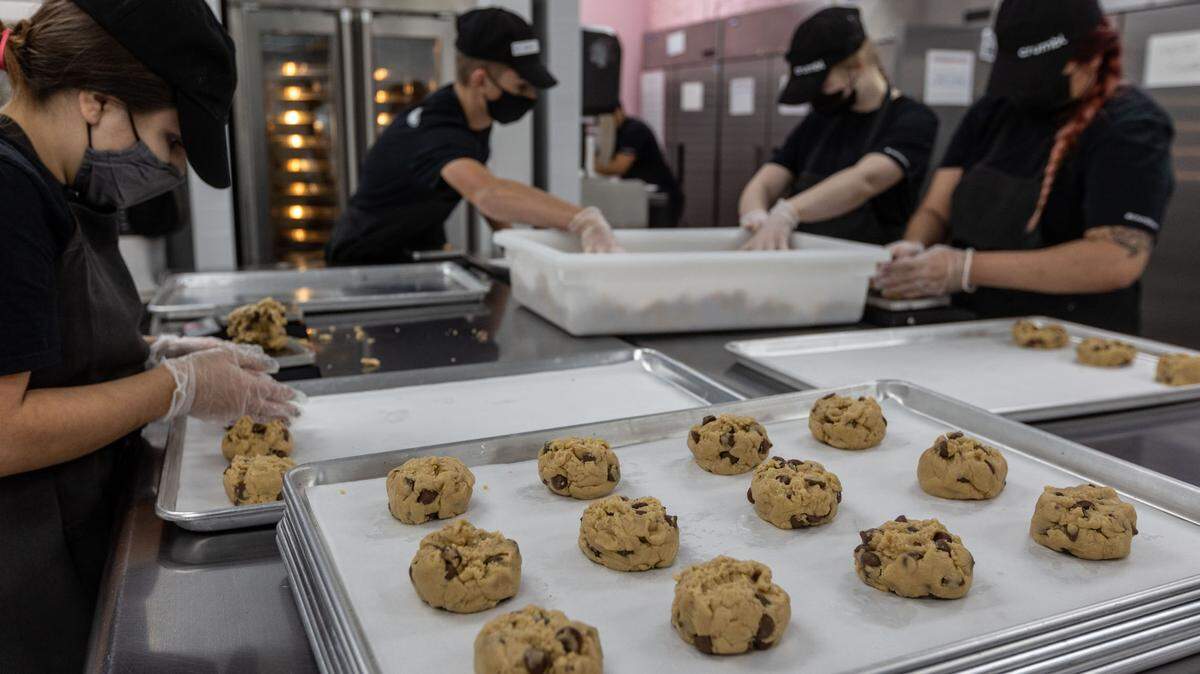 Workers measure out chocolate chip cookie dough in preparation to bake another batch of cookies at Crumbl Cookies in Kennewick. The popular chain made its Tri-Cities debut in Richland in March and will soon have locations in all three cities.