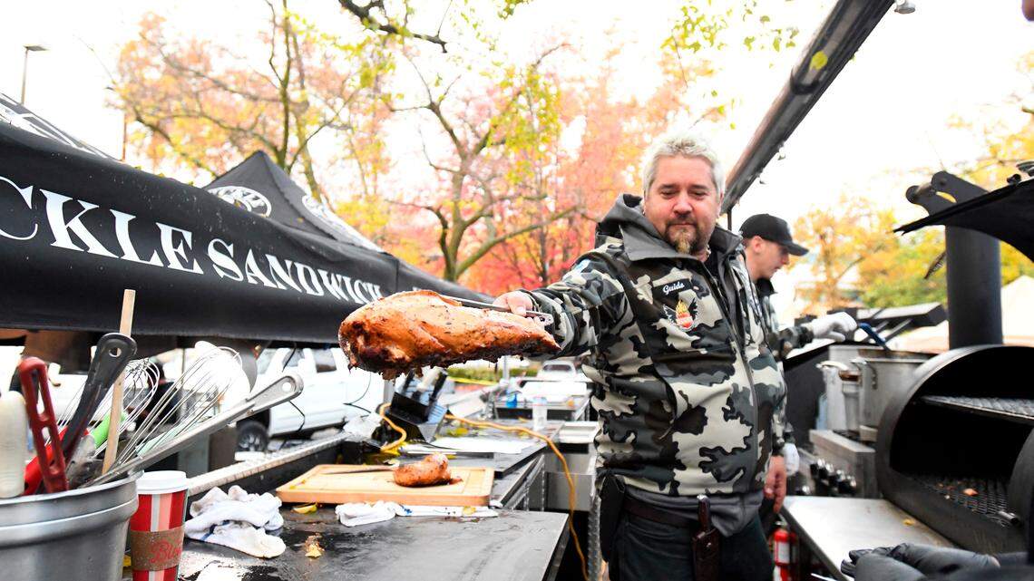 Chef Guy Fieri pulls a turkey from a grill, Thursday, Nov. 22, 2018, in Chico, Calif. Fieri was among the volunteers who showed up to prepare Thanksgiving meals for evacuees from the Camp Fire, which devastated the nearby town of Paradise, Calif. (Benjamin Spillman/The Reno Gazette-Journal via AP)