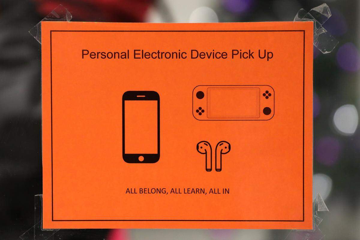 A sign for personal electronic device pick up, cellphones, is posted on the doors to the main office at Pasco High School.