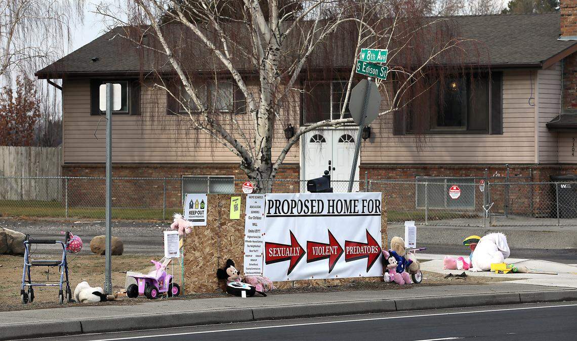 Neighbors in the area off West Eighth Avenue have placed a banner, various children's toys and stuffed animals along Edison Street in Kennewick opposing the decision to allow a home for sex offenders. 