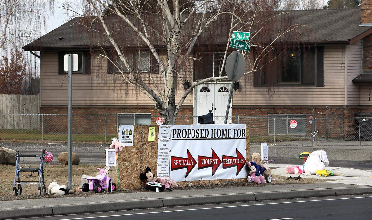 Neighbors in the area off West Eighth Avenue have placed a banner and various children's toy and stuffed animals along Edison Street in Kennewick opposing the decision to allow a home for sex offenders.