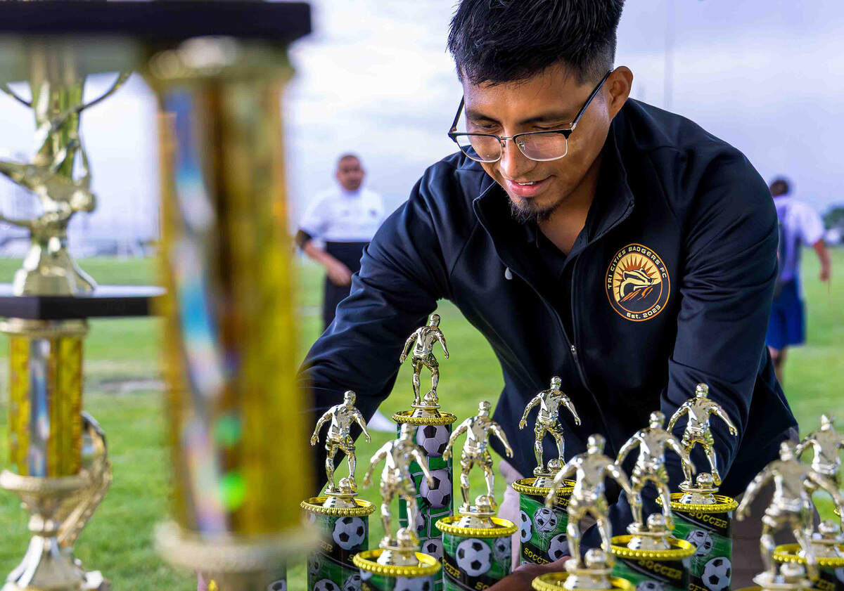 Alfredo "Freddy" Alcantara arranges championship trophies before the La Liga 1020 Division Championship match. He is one of the organizers helping support the local adult soccer community.
