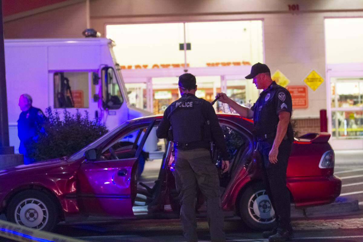 Officers search Matthew McQuin’s red Honda outside of Winco in Richland after he allegedly shot a woman inside the busy store. The Richland bomb squad was called in to make sure the car had no explosives.