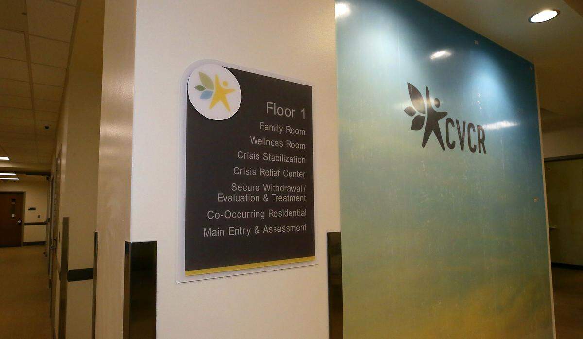 A colorful logo wall and a sign listing treatment areas is displayed in the public entrance to the Columbia Valley Recovery Center in downtown Kennewick. The facility that will offer mental health, sobering, detox and residential substance use treatment later this spring when it opens.