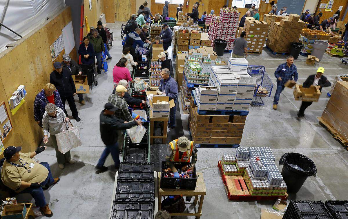 Volunteers assist recipients work their way through the line during a recent food distribution day at the St. Vincent de Paul Food Bank & Community Services campus in Pasco.