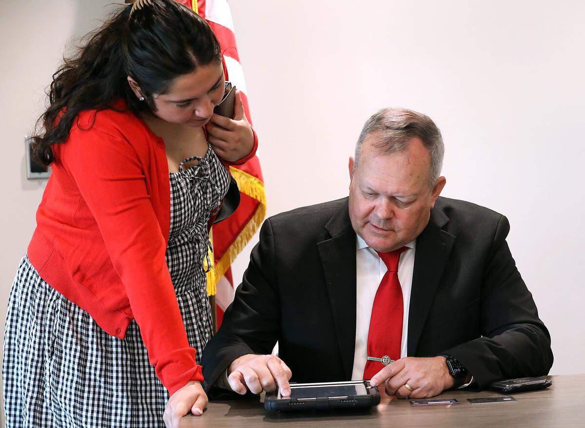 Matt Boehnke uses a tablet to file for 4th District Congressional race at the Benton County Elections Center in Kennewick. His campaign manager, Emily Garza, stands next to him.