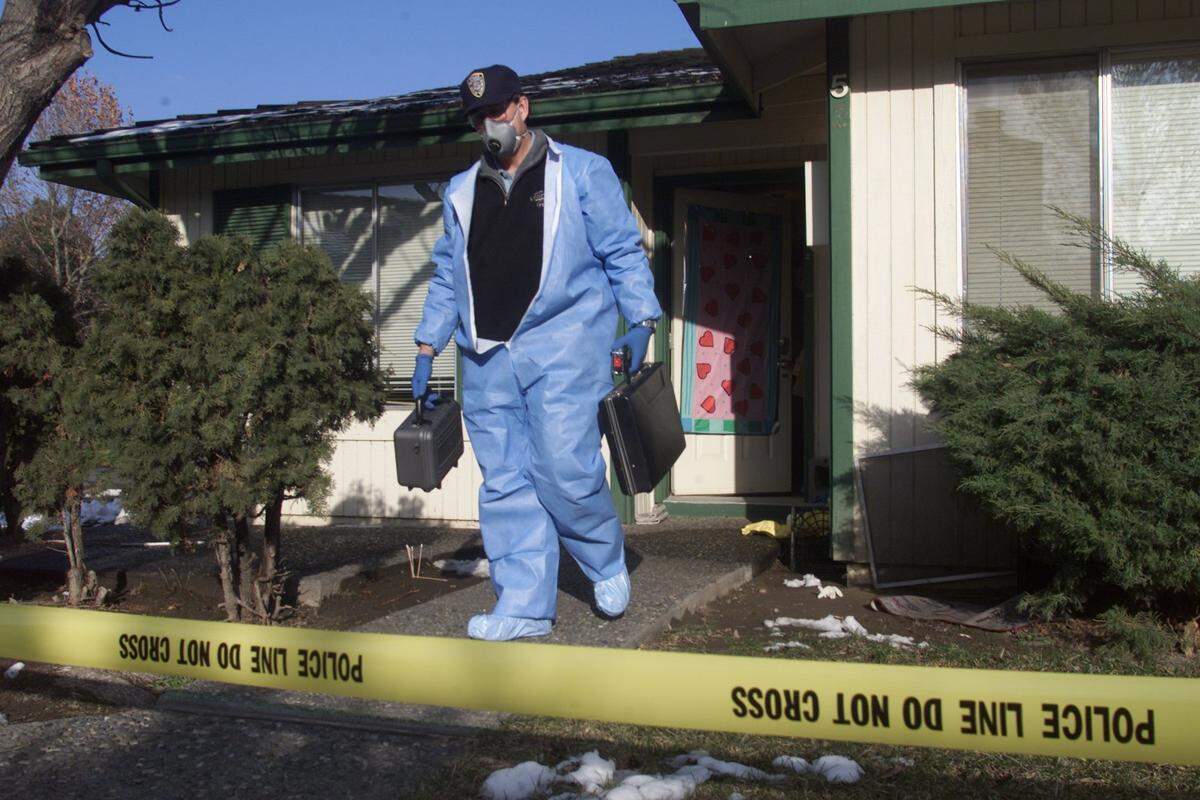 A Kennewick Police Department investigator leaves the scene of a homicide at 1107 W. Fifth Ave. in the Springtree Luxury Condo complex on Feb. 11, 2001. The body of Cassandra Annette Ray, 51, was found by police after her son called because he had not heard from her and was worried.