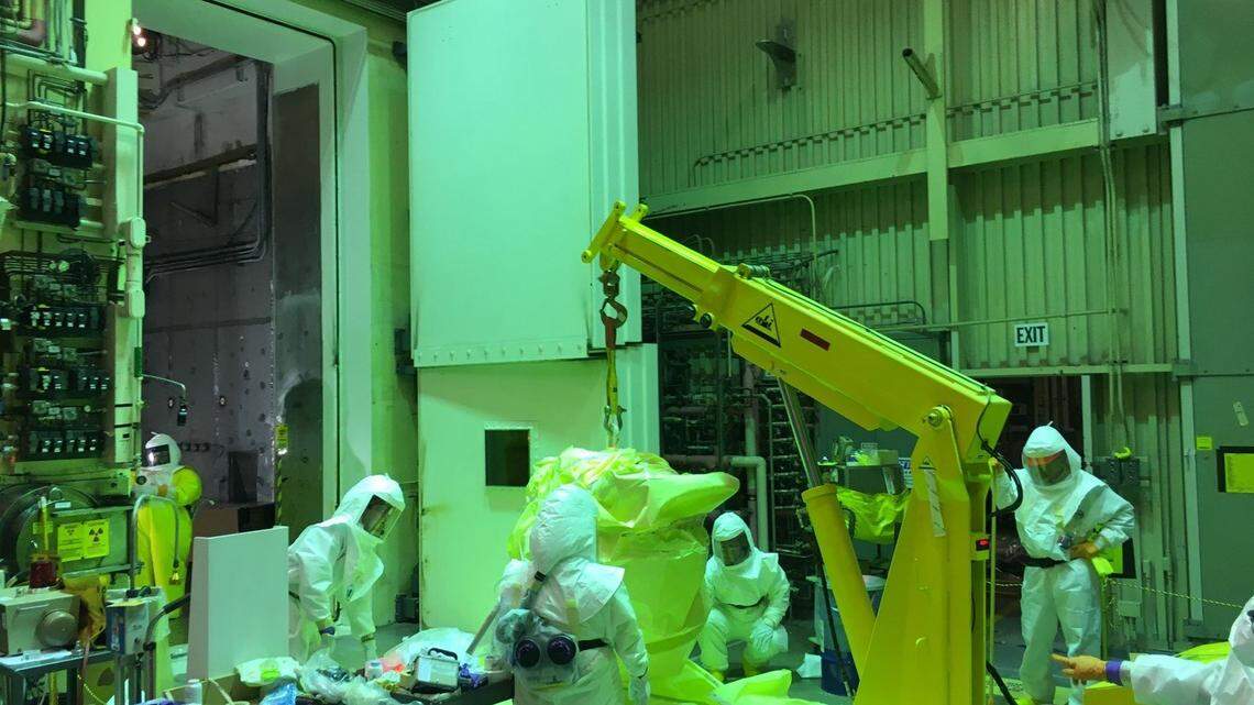 Workers remove waste items from the Hanford 324 Building as part of work assigned to CH2M Hill Plateau Remediation Co. CH2M's Hanford contract expires in September.