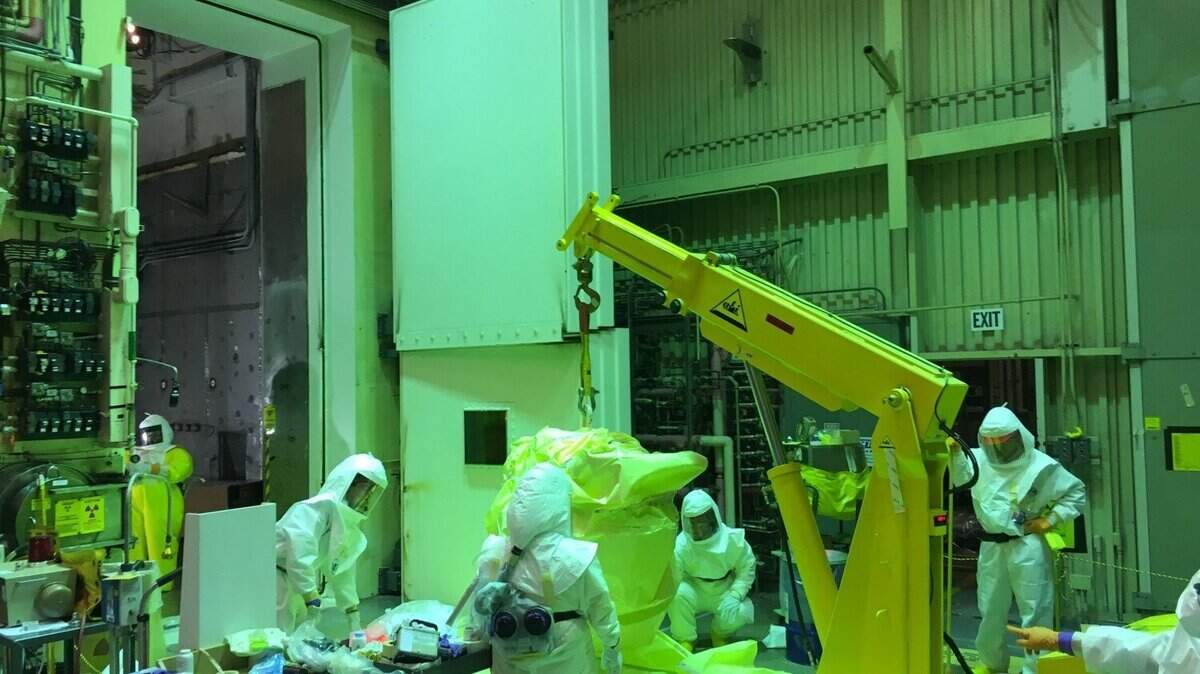 Workers remove waste items from the Hanford 324 Building as part of work assigned to CH2M Hill Plateau Remediation Co. CH2M's Hanford contract expires in September.