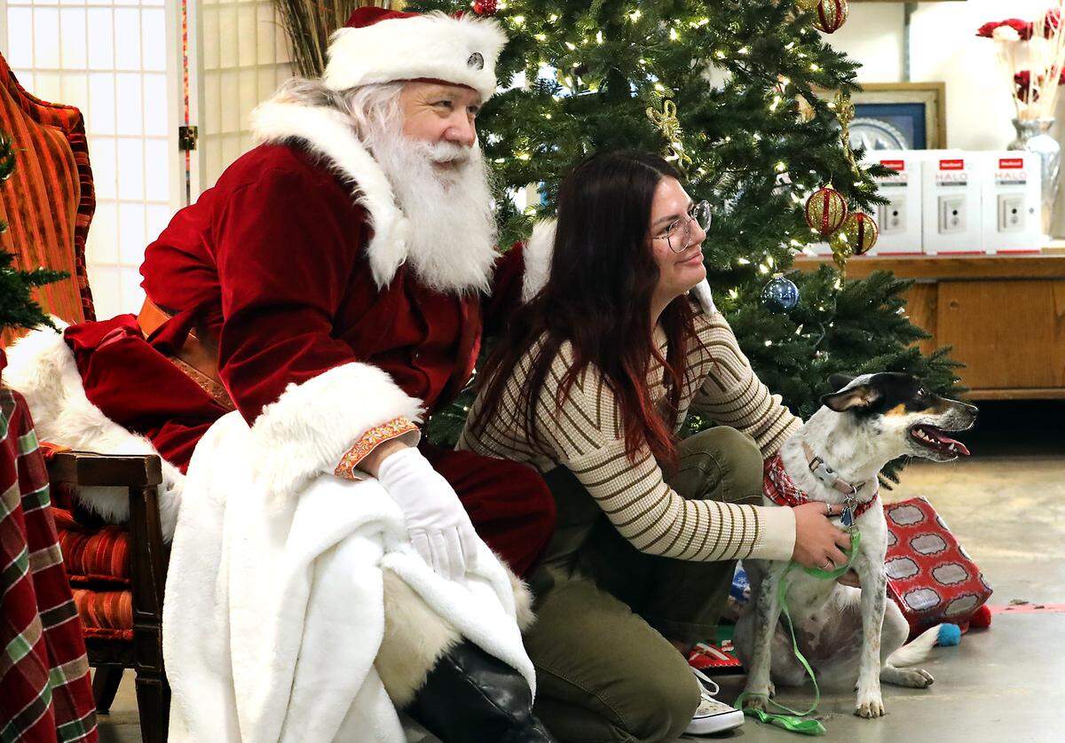 Jennifer Turner and her newly adopted Heeler mix named Gwen pose for a photo with Santa Claus.