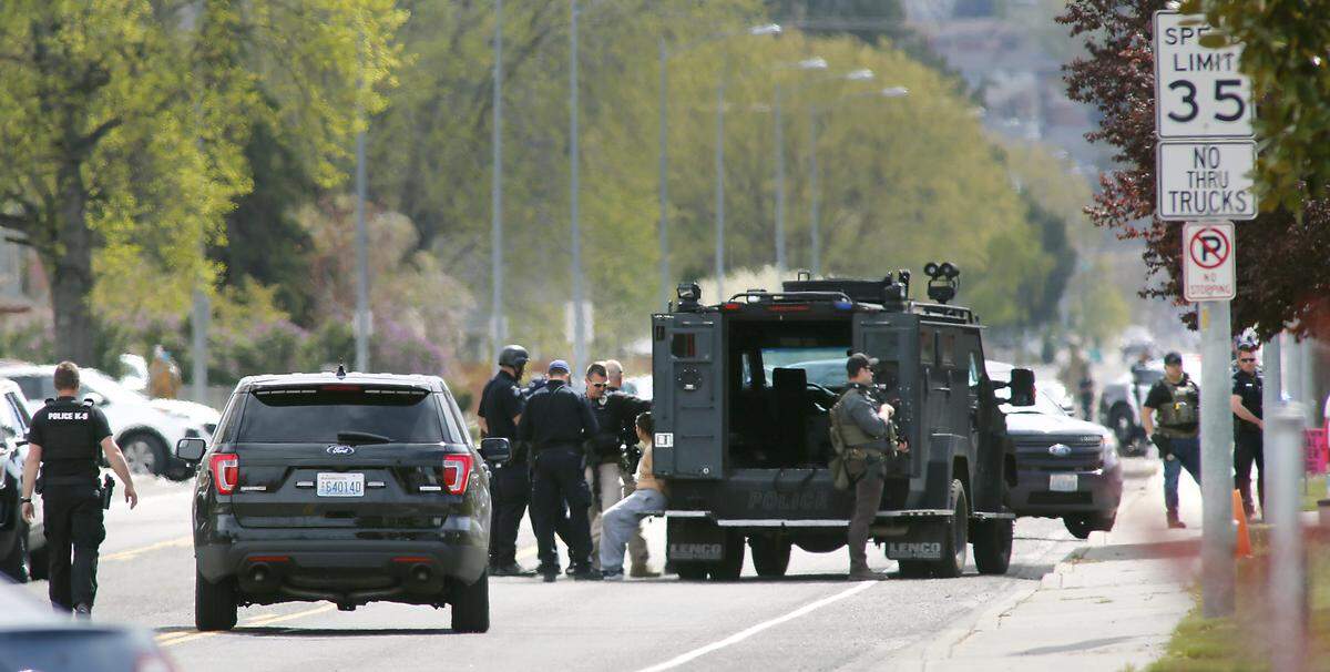 Police officers detain an unidentified male behind a SWAT vehicle parked on North Kellogg Street following a chase of a Franklin County murder suspect around noon Wednesday in west Kennewick. The wanted man ran away from police after abandoning a U-Haul pickup he was driving in a business parking lot in the 600 block of North Kellogg street. Police officers surrounded a home in the 100 block of North Lincoln Street and blocked traffic on Kellogg Street. Watch a video at at: tricityherald.com/videos