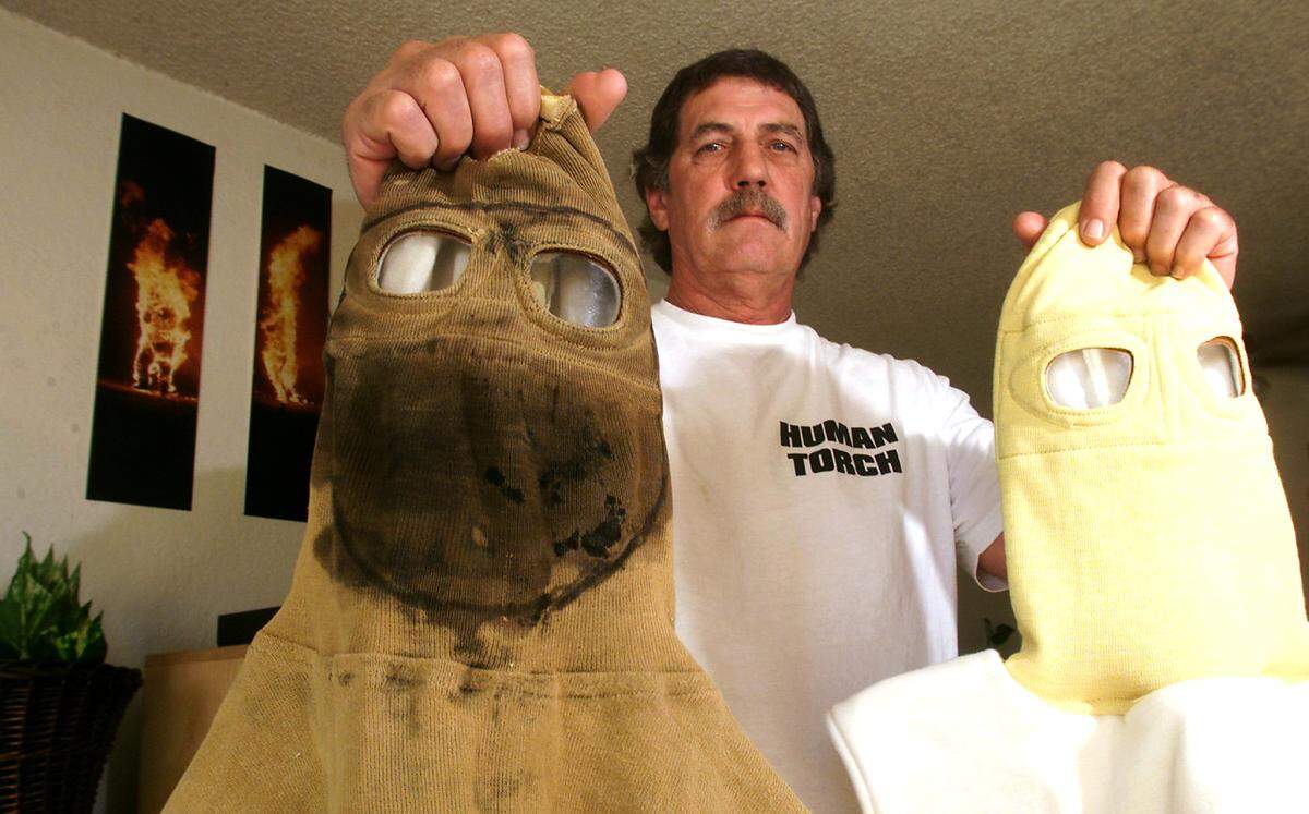 Gary Edelen of Kennewick, self-proclaimed human torch, displays a fire hood after 14 burns, left, and a new hood on the right in August, 2000.