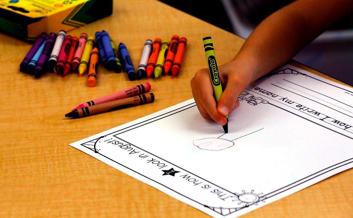 A new kidergarten student completes a drawing during Wednesday’s visit to Amon Creek Elementary Schoo.