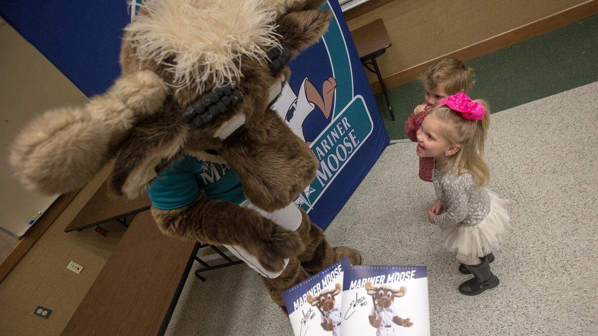 Siblings Addyson and Sylas Omta meet the Mariner Moose on Friday while their grandmother, Nicol Ramsey of Kennewick, takes a photos of them during the Mariners Caravan stop at Columbia Basin College in Pasco.