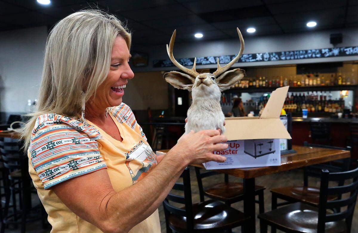 Laurie Winchel Atwood, owner of Jackalope Bar & Grill, unboxes a mount of the mythical animal hybrid that is the namesake of her business.